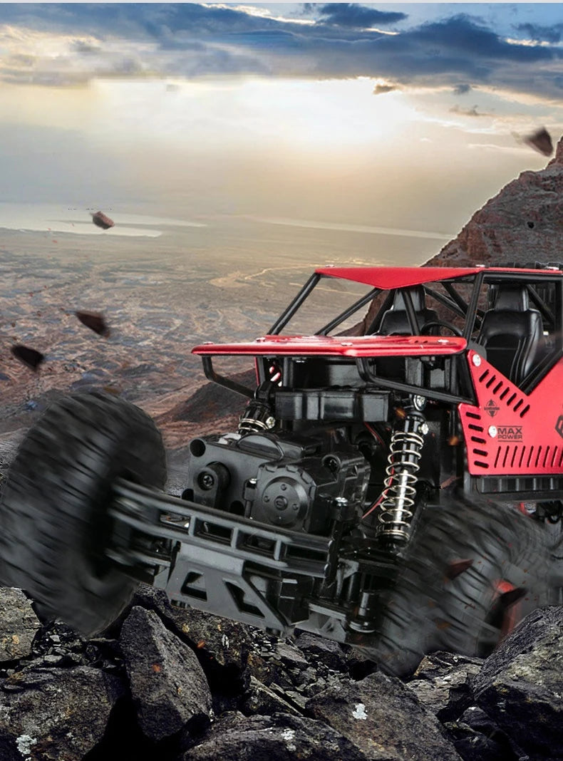 A red 4WD remote control stunt car is driving off-road over rocky terrain under a dramatic sky.