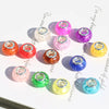 A collection of colorful resin spacer beads in various shades including pink, purple, orange, and yellow, displayed on a whit
