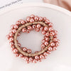 A circular crown of pink and nude pearls used as elegant hair ties or bow scrunchies.