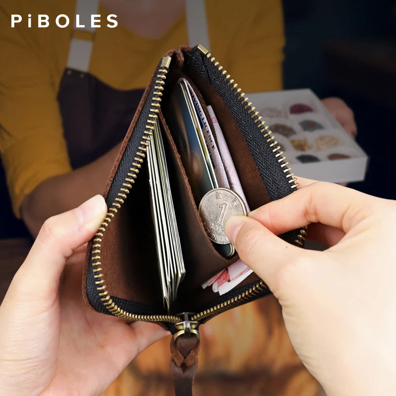 A hand holds a brown leather coin purse with a zipper open, displaying several coins.