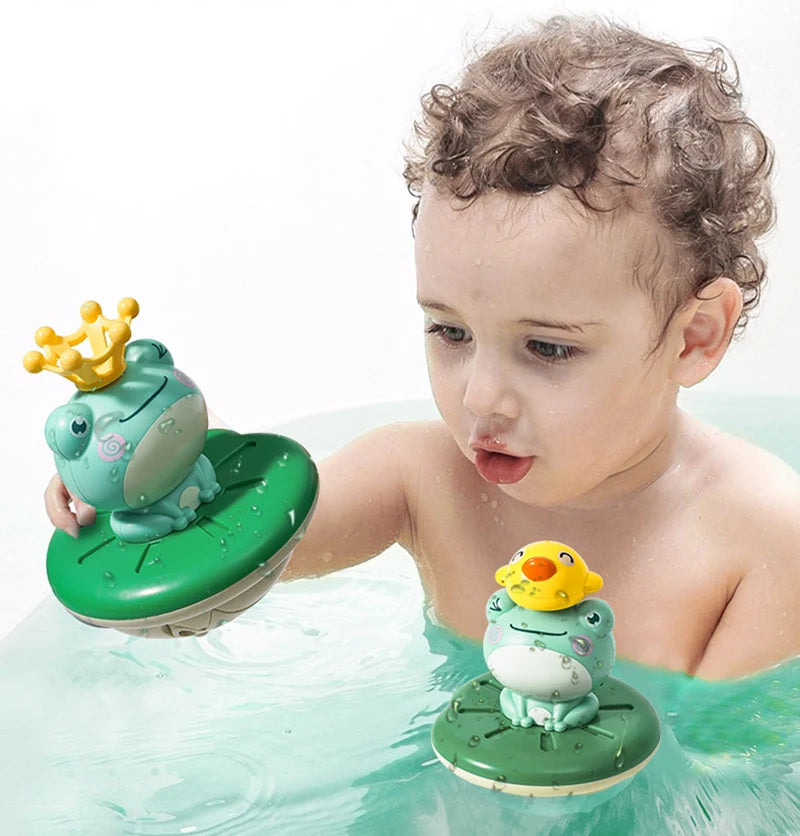 A baby is playing with a green frog bath toy that floats in water.
