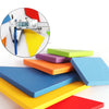 Colorful wooden tangram puzzle pieces arranged on a white surface with a measuring tool nearby.