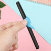 A hand holds a black automatic fade pen with a light blue refill, set against a pink and blue background.