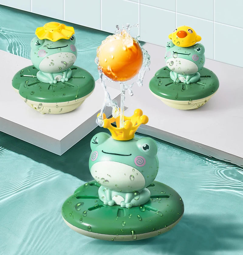 A set of three green frog bath toys with yellow heads and an orange sphere, featuring a floating water sprinkler design.