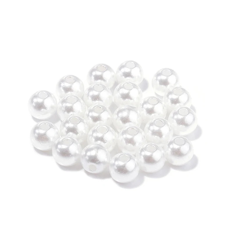 A pile of small, white imitation pearl beads for DIY jewelry making.