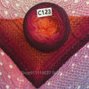 A dark purple yarn ball with an orange and pink gradient is placed on a pink knitted fabric.