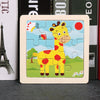 A wooden jigsaw puzzle featuring a yellow giraffe in a grassy landscape with red and orange accents.