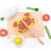A magnetic wooden fruit and vegetable cutting toy set featuring a red fish, yellow lemon, and green pieces on a wooden board.