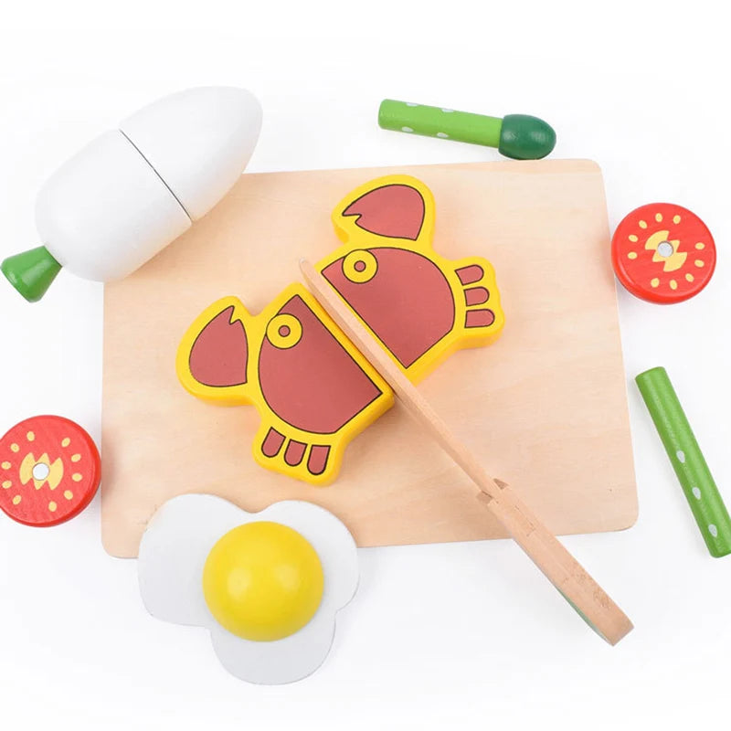 A magnetic wooden fruit and vegetable cutting toy set featuring a red fish, yellow lemon, and green pieces on a wooden board.