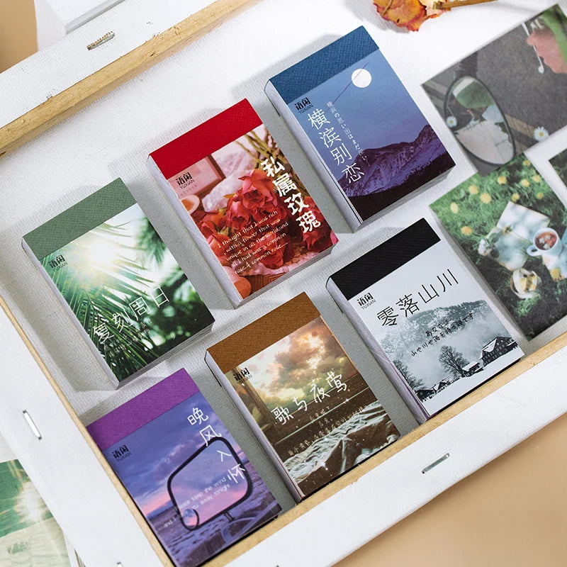 A collection of aesthetic landscape stickers in a booklet featuring nature and art designs for scrapbooking