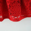 A close-up of a red lace princess dress with a doll collar, showing the intricate pattern and fabric texture.