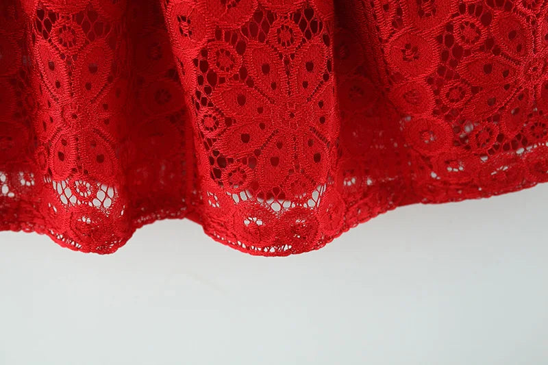 A close-up of a red lace princess dress with a doll collar, showing the intricate pattern and fabric texture.
