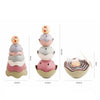 A set of boat-shaped stacking cups bath toys for toddlers in pastel colors like pink, gray, and beige.