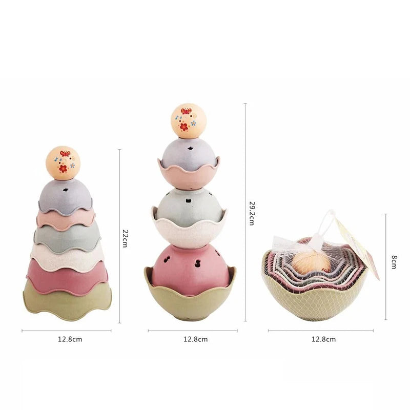 A set of boat-shaped stacking cups bath toys for toddlers in pastel colors like pink, gray, and beige.