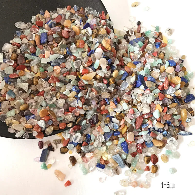 A pile of natural mixed quartz crystal stones in various colors including clear, blue, pink, and amber.