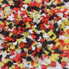 A close-up view of colorful cartoon polymer clay slices in red, yellow, white, and black mixed together.