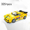 A yellow classic rally car building block set with racing numbers on the hood and side, shown in a studio setting.