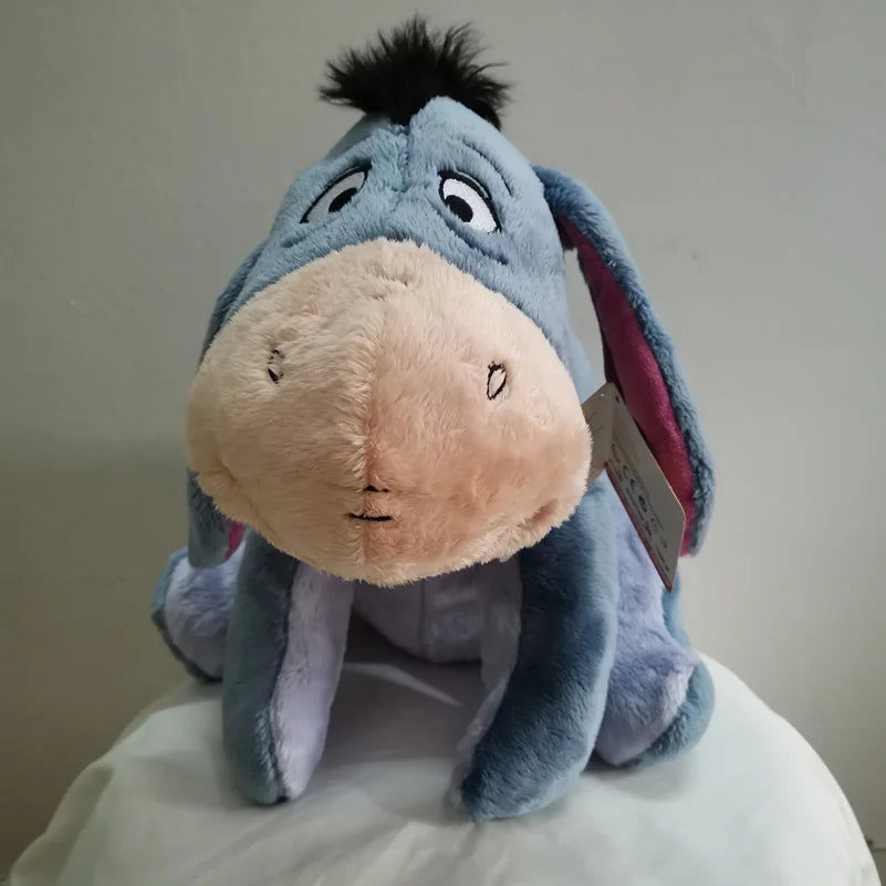 A soft blue Eeyore plush toy resembling a donkey with pink accents.