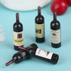 A set of miniature resin wine bottles, including a port bottle, displayed on a light blue surface.