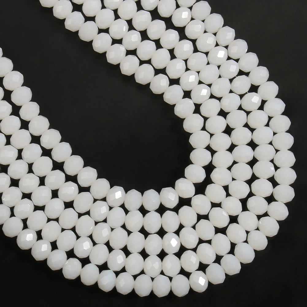 A close-up of a strand of white faceted crystal glass beads arranged in a U shape.