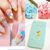 Close-up of colorful polymer clay slice sprinkles used for slime and DIY crafts displayed on fingernails and a smartphone.