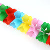 A colorful arrangement of magical trick bags shaped like flowers in various shades of pink, blue, yellow, and green.