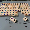 A grid of wooden gemstone building blocks featuring various colored acrylic crystals arranged in rows.