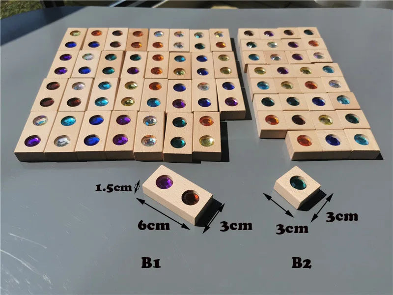 A grid of wooden gemstone building blocks featuring various colored acrylic crystals arranged in rows.