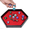 A hand holds several colorful hexagonal dice inside a black tray with a red velvet interior.