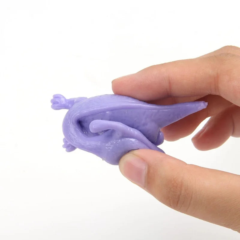 A hand holds a purple stretchy rubber chicken slingshot fidget toy.