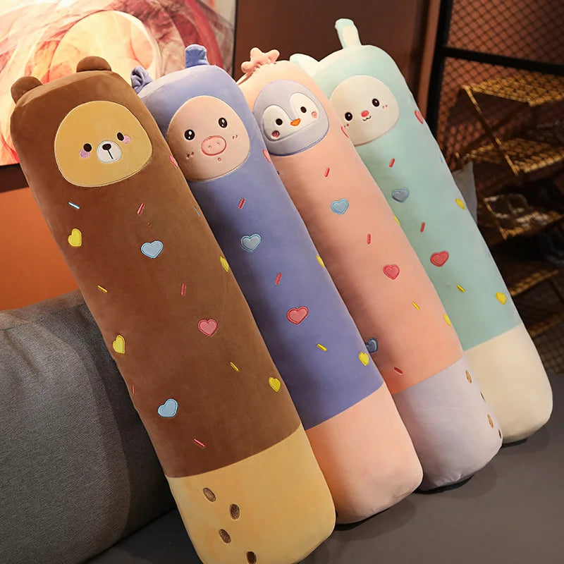 A collection of five long body kawaii stuffed animal plush pillows in pastel colors like yellow, purple, pink, and mint green