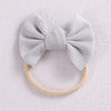 A light gray ribbed bow headband with a beige elastic band, photographed against a white background.