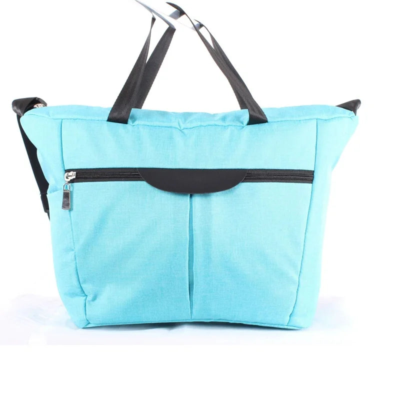 Light blue fabric bag with black straps and a black pocket, used as a stroller accessory kit.