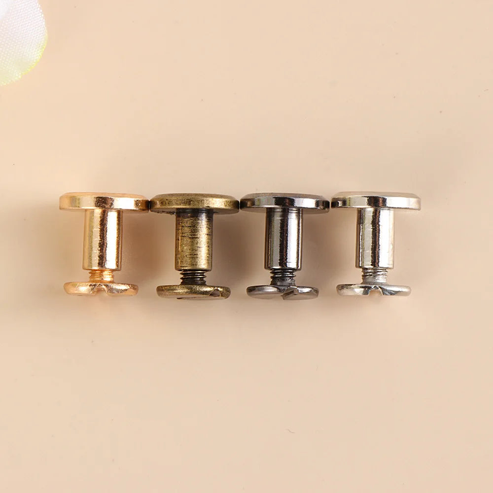 Four decorative heart brass rivets with silver and gold finishes arranged in a row.