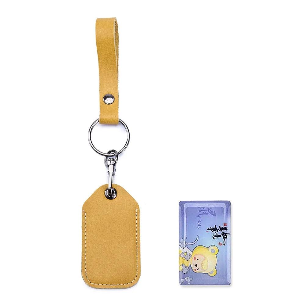 A tan leather key wallet with a strap and a small card holder attached to a metal ring.