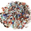 A pile of natural mixed quartz crystal stones in various colors including pink, blue, and clear translucent shades.