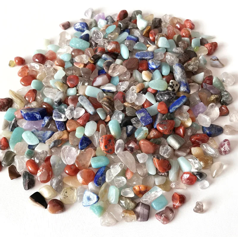 A pile of natural mixed quartz crystal stones in various colors including pink, blue, and clear translucent shades.