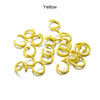A pile of yellow metal open jump rings for DIY jewelry making.
