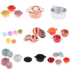 A collection of miniature copper and silver soup pots and accessories for a dollhouse kitchen.