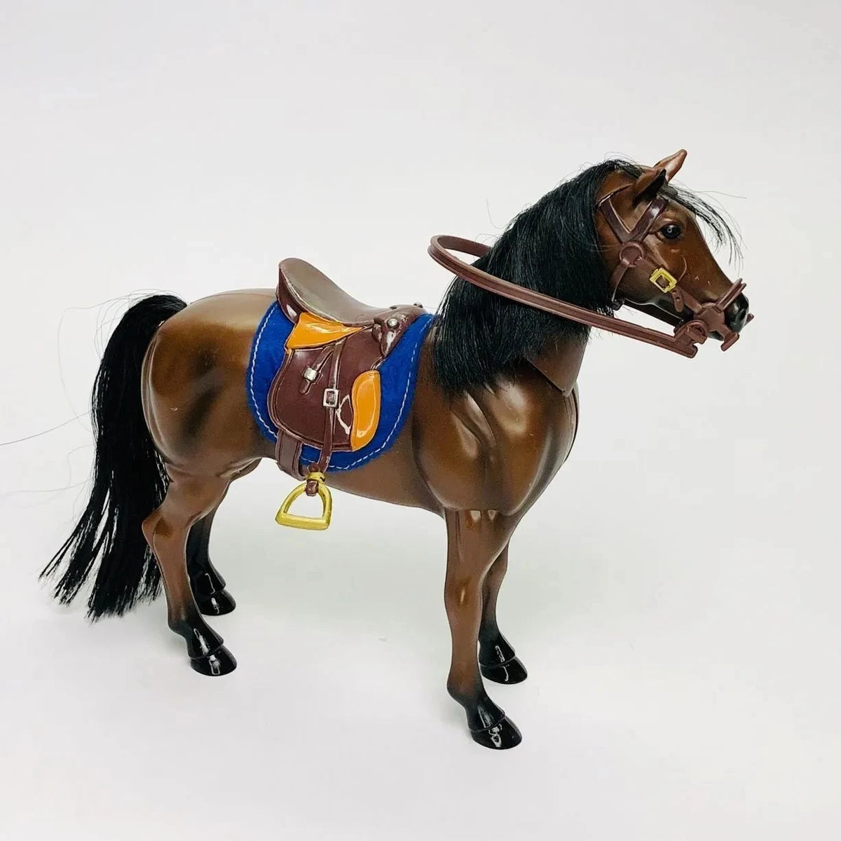 A 1/12 scale dollhouse horse with a brown coat, black mane and tail, wearing a brown leather saddle and riding prop.