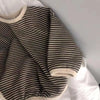 A close-up of a kids cotton pullover sweatshirt with horizontal dark brown and cream stripes.