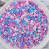 A bowl filled with heart-shaped fake candy sprinkles in various pastel colors like pink, purple, and blue for slime and craft