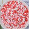 A bowl filled with heart-shaped fake candy sprinkles in shades of pink and white for slime and craft decorations.