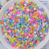 A bowl filled with heart-shaped fake candy sprinkles in various bright colors for slime and craft decorations