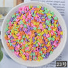 A bowl filled with heart-shaped fake candy sprinkles in various bright colors for slime and craft decorations