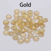 A collection of small, gold-colored flower petal bead caps for jewelry making.