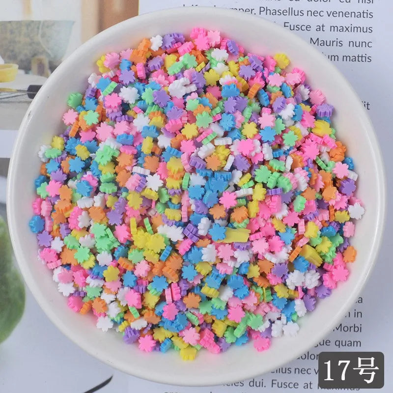 A bowl filled with heart-shaped fake candy sprinkles in various bright colors for slime and craft decorations