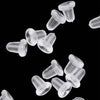 A close-up view of clear silicone earring backs scattered on a black background.
