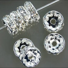 A collection of crystal rondelle spacer beads for jewelry making, showing various sizes and shapes.