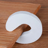 Tapón para puertas de EVA blanca con forma curva sobre una superficie de madera.